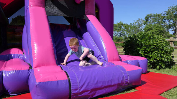 Red headed boy having fun playing on a bouncy castle