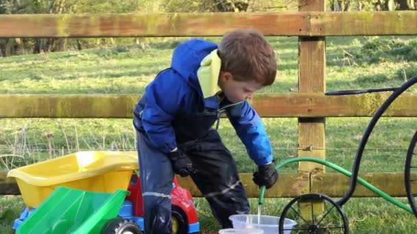 Маленький Хлопчик Грає Водою Саду — стокове відео