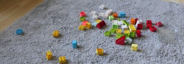 Renkli Lego Parçalarının karışımı. Kapalı bir paspasın üzerinde oturuyor.