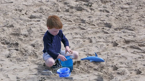 Κόκκινο Επικεφαλής Αγόρι Παίζει Μια Αμμώδη Παραλία Στη Βόρεια Ιρλανδία — Φωτογραφία Αρχείου