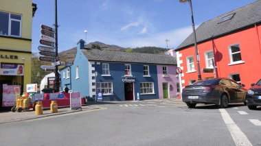 Carlingford Village, Co Louth Ireland 'da bir caddedeki renkli boyalı dükkanlar ve barlar 06-06-22