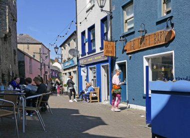 Carlingford Village, Co Louth Ireland 'da bir caddedeki renkli boyalı dükkanlar ve barlar 06-06-22
