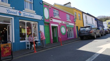 Carlingford Village, Co Louth Ireland 'da bir caddedeki renkli boyalı dükkanlar ve barlar 06-06-22