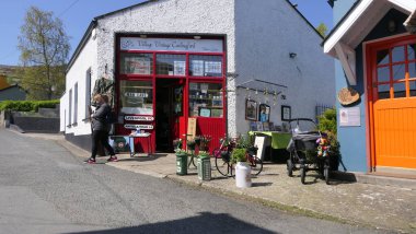 Carlingford Village, Co Louth Ireland 'da bir caddedeki renkli boyalı dükkanlar ve barlar 06-06-22