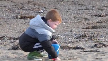 Red headed boy playing on a sandy beach in Northern Ireland Holidays 