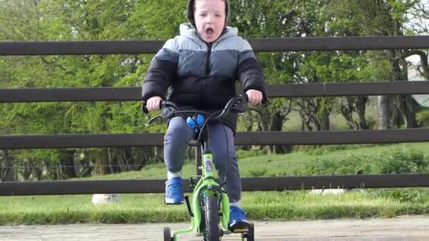 Червона Голова Хлопчик Весело Грає Своєму Велосипеді Саду — стокове відео