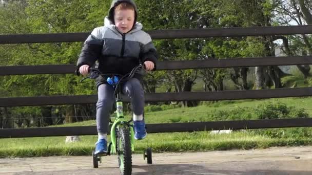 Menino Cabeça Vermelha Divertindo Jogando Sua Bicicleta Jardim — Vídeo de Stock