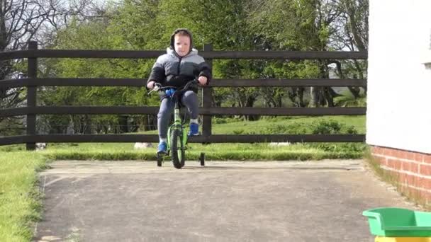 Rudy Chłopiec Bawiący Się Rowerze Ogrodzie — Wideo stockowe