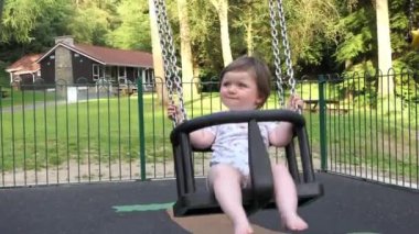 A small Girl having fun on a Swing in a Playpark