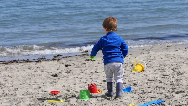 Рыжий Мальчик Играет Ведром Лопаты Диггер Песчаном Пляже — стоковое фото
