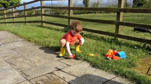 Red Headed Boy Having Fun Playing His Toys Garden — 图库照片