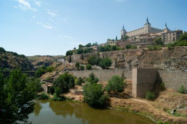 Toledo, İspanya 'nın tarihi Alcazar Kalesi' nin dramatik manzarası Tagus Nehri 'nin yukarısındaki heykel ufuk çizgisi manzarasına fotokopi uzayı ile hakim.