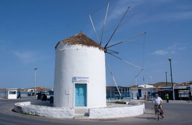 Paros Adası - Yunanistan - 13 Mayıs 2010: Feribot iskelesindeki geleneksel Yunan ada yel değirmeni Bu büyüleyici ada manzarası Mavi gökyüzü ve uzay kopyası