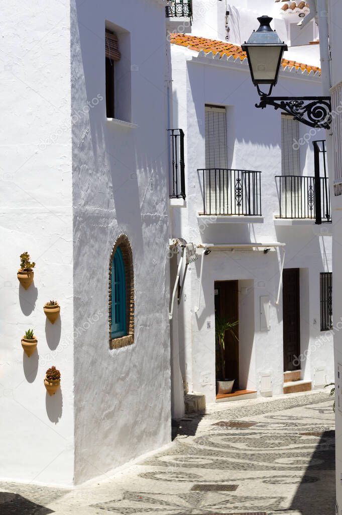 Beautiful Frigiliana village, southern Spain Charming pretty alley Traditional architecture with old fashioned white painted town houses  Vertical shot