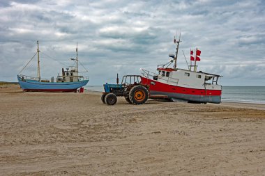 Fjerritslev, Jutland, Danimarka - 11 Eylül 2020: Bir traktör Thorup Strand, Jutland, Danimarka 'da bir balıkçı teknesini kıyıya çekti