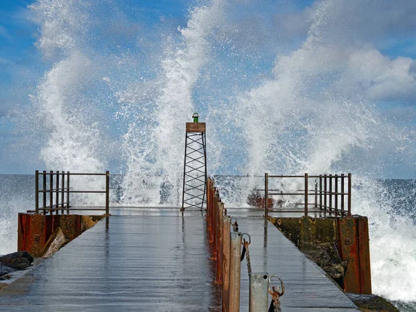 Lighthouse in swell with splashing waves on the Danish North Sea coast of Vorupor