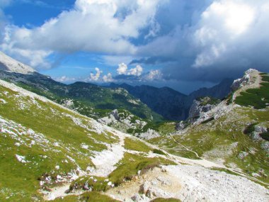 Triglav Ulusal Parkı 'ndaki Planika dağ kulübesine giden yolun manzaralı manzarası ve Slovenya' nın Gorenjska bölgesindeki Julian Alp 'leri ve arkada kara fırtına bulutları