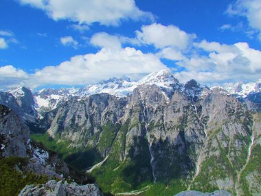 Slovenya 'nın Gorenjska kentindeki Julian Alpleri' ndeki Triglav Dağı 'nın manzarası. Zirvesi karla kaplı ve Krma Vadisi' nde orman taze yeşil bahar yapraklarıyla böğürüyor.