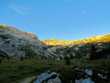 Krn Dağı 'nın zirvesinin Triglav Ulusal Parkı ve Slovenya' nın Julian Alpleri 'ndeki sabah güneşiyle aydınlanması