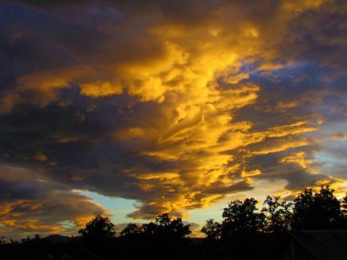 Alacakaranlıktaki güzel bulutlar turuncu renkli güneş ışığıyla aydınlanıyor.