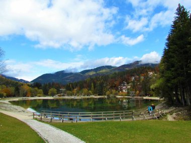 Slovenya 'nın Kranjska Gora n Gorenjska kenti yakınlarındaki Jasna Gölü' nde gölün ve ormanın arkasındaki tepelerin ve evlerin yansımaları görülüyor.