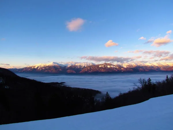 冬季日落时斯洛文尼亚戈伦伊斯卡的卡拉万科山脉 大雾笼罩着盆地 — 图库照片