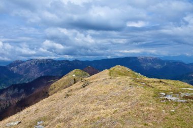 Güneşle aydınlanan Porezen Dağı 'nın ve bulutlu bir günde arkadaki Ratitovec Dağı' nın sırtı görünüyor.
