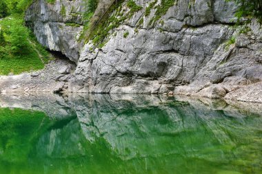 Triglav gölündeki Crno Jezero Gölü 'nün üzerindeki kaya duvarı ve Slovenya' daki Julian Alpleri