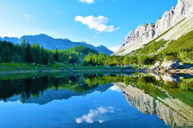 Triglav Gölü 'ndeki Dvojno Jezero ya da Dvojno Gölü' nün manzarası gölün etrafındaki dağların yansıması ve diğer tarla ormanı.