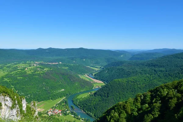 Kozice perspektifinden Slovenya 'nın Dolenjska kentindeki Stari Trg ob Kolpi köyü ve orman ile çevrili Kolpa nehir vadisinin manzarası