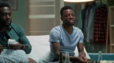 Siyahi adam alkışlıyor ve arkadaşlarıyla maç yapıyor.