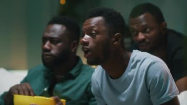 Mutlu siyah adam arkadaşlarıyla favori takımın zaferini kutluyor.