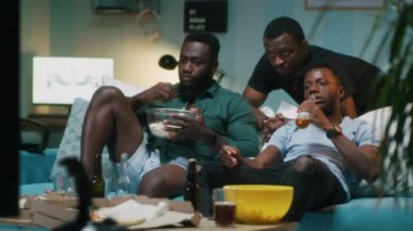 Afrika kökenli Amerikalı erkek oturma odasında maç tartışıyor.