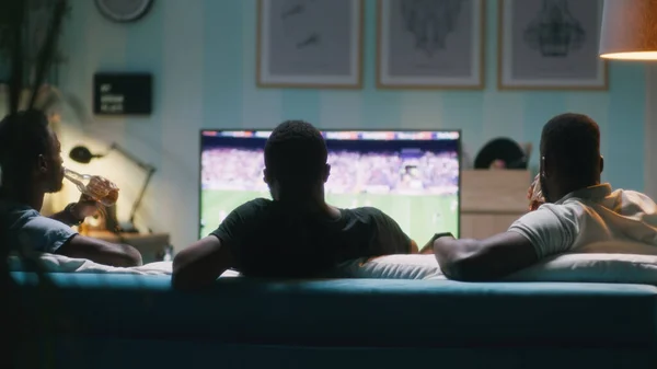 Black friends drinking beer during soccer match — Stock Photo, Image