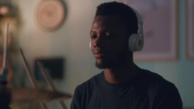 Afrikalı Amerikalı adam karanlık odada davul çalıyor.