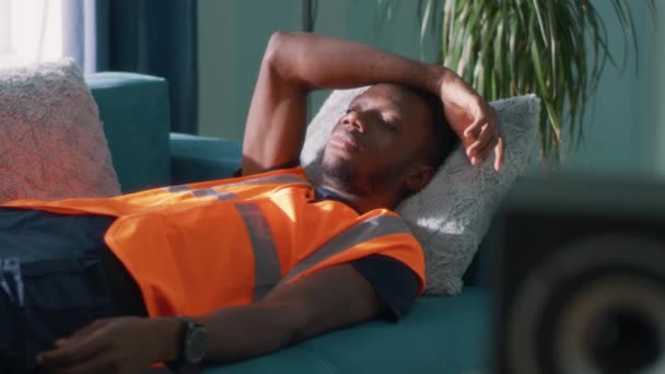 Чорний працівник спить на дивані — стокове відео
