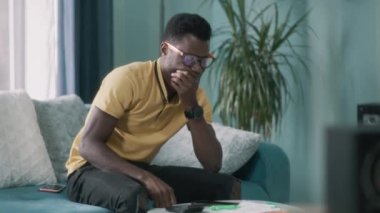 Üzgün siyah adam faturaları kontrol ediyor.