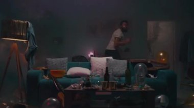 Adam oturma odasında dans ediyor.