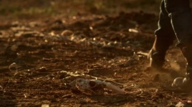 Kuru toprakta yürüyen çiftçi.