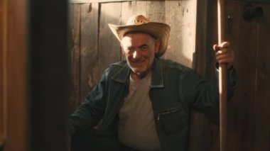 Ahırda oturan kıdemli çiftçi