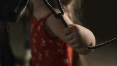 Çiftçi kız ahırda at besliyor.