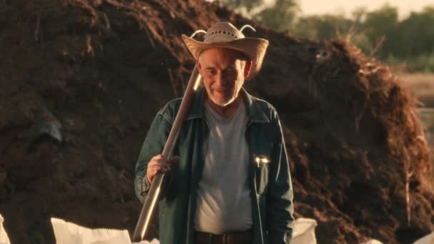 Aged farmer near heap of dirt — Stock Video