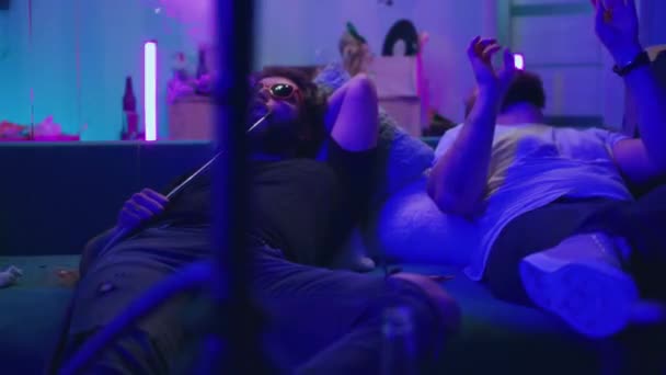 Άνδρες ψύξη στον καναπέ κατά τη διάρκεια της νύχτας κόμμα — Αρχείο Βίντεο