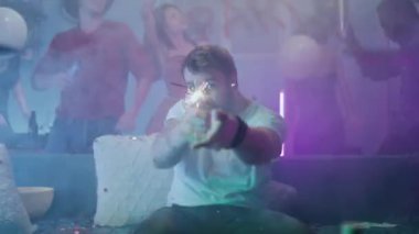 Parti sırasında maytaplı adam dans ediyor.