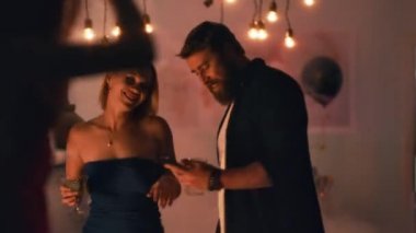 Dans eden çift parti sırasında akıllı telefon kullanıyor.