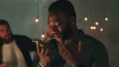 Afrikalı Amerikalı adam sesli mesaj kaydediyor ve arkadaşlarıyla iletişim kuruyor.