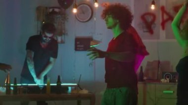 Genç adam parti sırasında duman içinde dans ediyor.