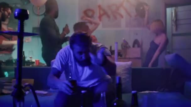 Мужчина пьет алкоголь во время вечеринки на диване — стоковое видео