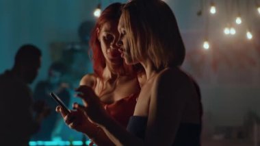 Parti sırasında akıllı telefon kullanan kadınlar