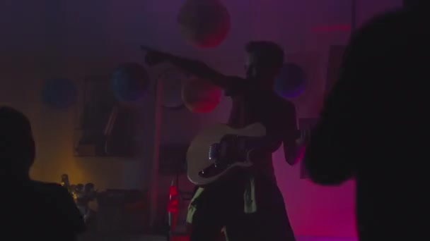 Adolescente tocando la guitarra cerca de público bailando — Vídeos de Stock